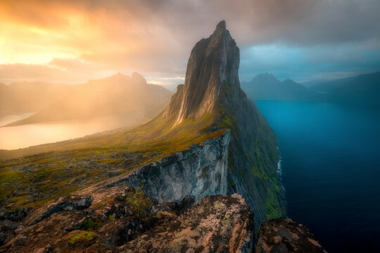 View of majestic Segla Mountain at sunset with dramatic sky and serene sea, Senja Island, Norway.