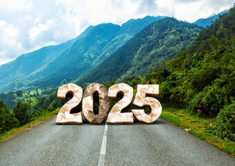 Stones in the shape of 2025 on the road against the background of mountains