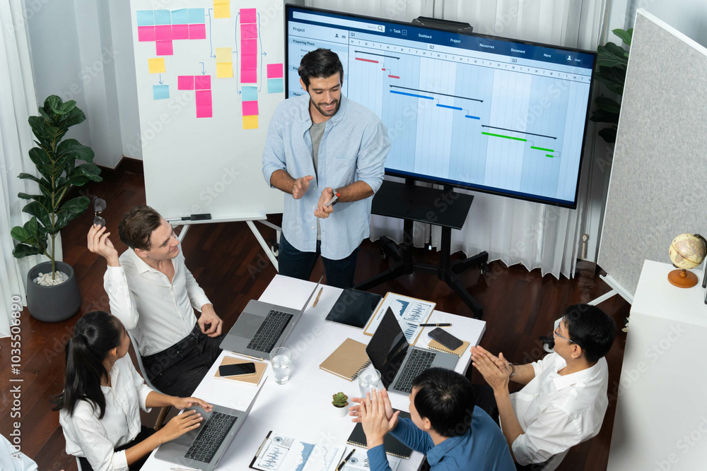 Poster Project manager communicate and collaborate with team using project management software display on monitor, tracking progress of project task and making schedule plan at meeting table. Prudent