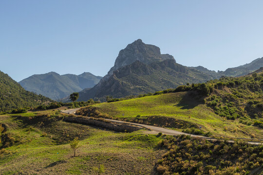 View of majestic mountains and hills with a scenic path in the tranquil countryside, Rte d'Akchour, Morocco.