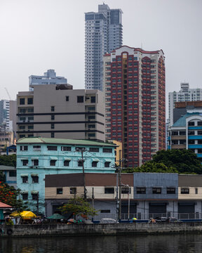 View of urban skyline with modern high-rise buildings and a river, Intramuros, The Philippines.