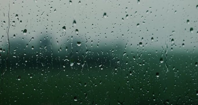 window with rain. rain falling on a window. background of rain on a window cinematic look. raindrops falling on a window