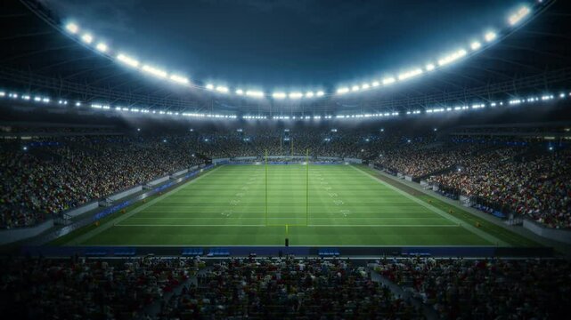 Night View of a Packed American Football Stadium. Thousands of Spectators Fill the Stands Surrounding the Game Field, Ready for a Major Sport Event. Behind the Goal Posts Static Camera Shot