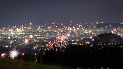 View of vibrant fireworks illuminating the night sky over the cityscape of Graz, Styria, Austria.