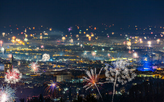 View of vibrant fireworks illuminating the skyline during new year's eve celebration, Graz, Austria.