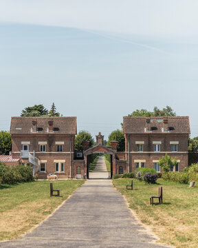 View of the serene Abbey of Our Lady of Dombes surrounded by picturesque greenery and brick buildings, Le Plantay, France.