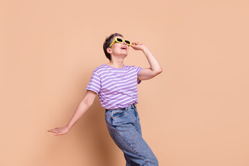 Photo of lovely adorable senior woman wear striped stylish clothes look empty space isolated on beige color background