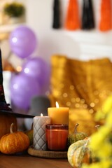 Burning candles and pumpkins on wooden table indoors, space for text. Halloween celebration