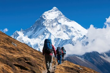 Obraz premium A group of hikers trekking towards a majestic snow-capped mountain under a clear blue sky, showcasing the beauty of adventure and nature.