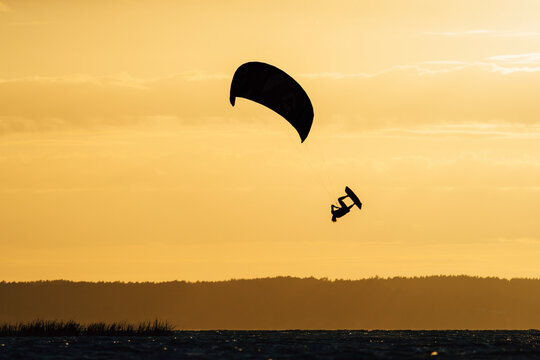 Kiteboarder doing extreme kiteloop move in the air with short lines.