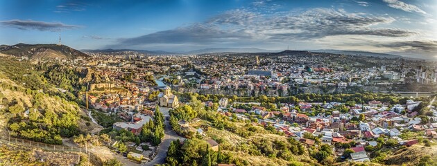 Drone panorama of Tbilisi, Georgia, with the Kura River at sunrise showcasing the cityscape © Aquarius