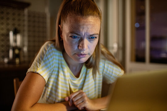 Young woman working on laptop late at night