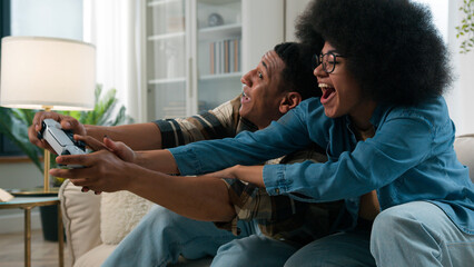 African American family at home couch man guy boyfriend playing video game play console addict...