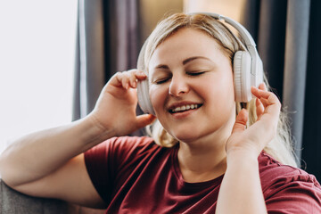 Happy beautiful woman touching headset enjoying favorite melody sound track