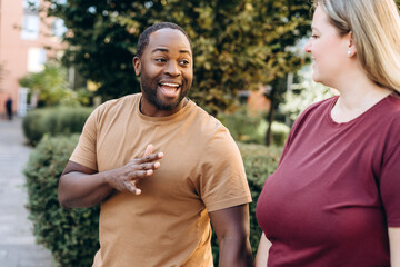 Obraz premium Funny African American man dating with plus size woman in the city