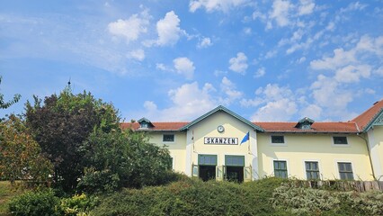 Historic building with a green roof and cloudy sky in the background