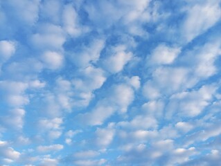 The texture of the blue sky drawn and covered with many small clouds. An unusually beautiful sky overhead.