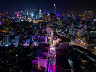 Aerial view of downtown Ho Chi Minh City and the illuminated Bui Vien party street at night,...