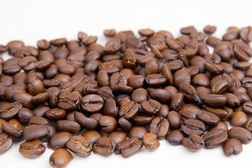 Naklejka premium Coffee beans in a white. Caffeine drink closeup concept. A strip of brown coffee beans on white . A strip of brown coffee beans lifestyle on a white.
