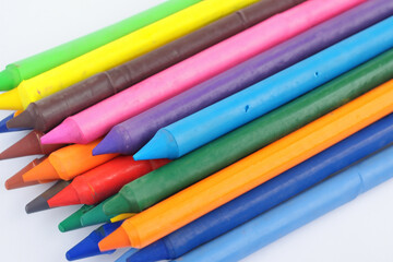 Fototapeta premium Gray with bunch of colored chalks. chalk color texture concept. stack of crayons on a grey . a stack of colored crayons on a gray with a spool of colored pencils lifestyle.