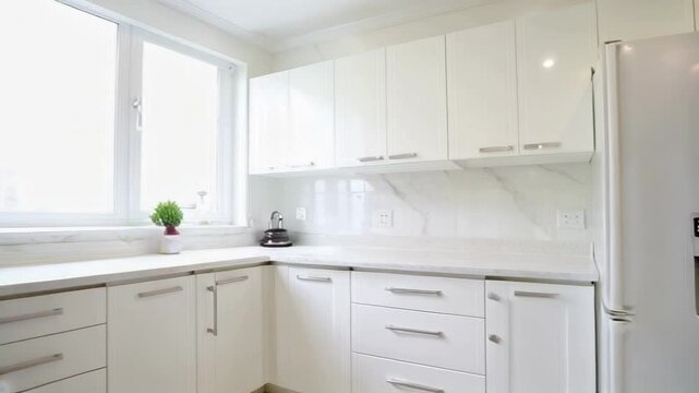 A bright, modern kitchen featuring minimalist design, clean lines, and organized space, evoking a sense of comfort and functionality.