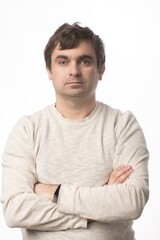 A man in a beige sweater with folded arms standing against a clean white background. Ideal for professional and personal projects that emphasize simplicity and confidence.