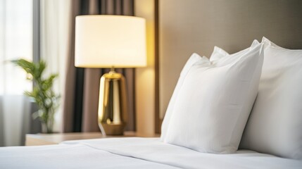 A cozy hotel room with white pillows and a stylish lamp, creating a relaxing atmosphere.