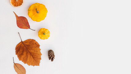 Autumn holiday frame composition with pattern made of leaf, punpkins, dried orange, pine cone on...