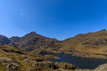 Scenic mountains and tranquil lake under blue sky.