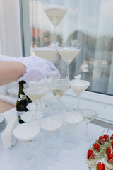 a pyramid of champagne glasses in a restaurant at a wedding