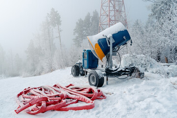Snow cannon, machine or gun snowing the slopes or mountain for skiers, artificial snow