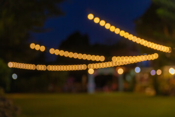 vintage tone blur image of food stall at night festival with bokeh for background usage. Festival Event Party with People Blurred Background. Blur people having sunset beach party in summer vacation