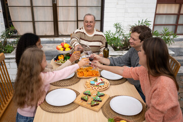 Grandfather, parents, and the teenage girls are all having dinner together at home