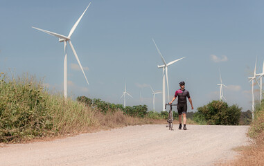 Obraz premium Cyclists are riding their bikes for training and touring the wind farms