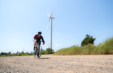 Cyclists are riding their bikes for training and touring the wind farms
