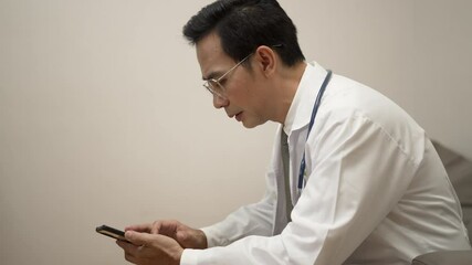 Doctor play mobile phone at hospital. Health care, technology. - Powered by Adobe