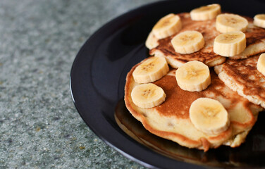 Desayuno de panqueques con banano, espacio para texto al lado izquierdo.