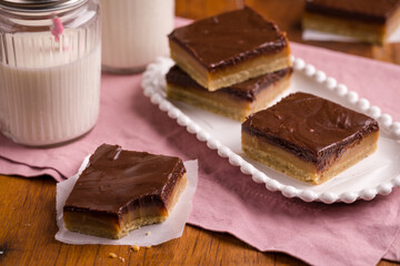 Delicious Chocolate Caramel Dessert Squares With Milk Served On Table