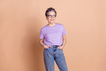 Photo of lovely adorable woman wear striped trendy clothes empty space isolated on beige color...