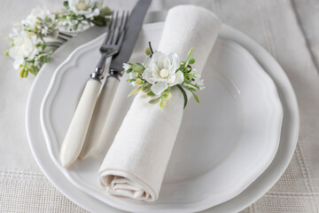 White flower napkin decoration and cutlery on plates, floral place setting arrangement