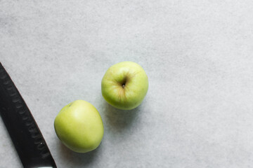 Overhead view of a whole green apple on a white granite countertop, top view of a crisp green apple on a white countertop