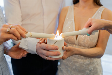 a lighted candle in the hands of people at the holiday