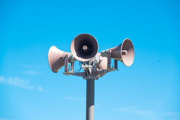 Public address speakers megaphones on a pole (PA). Four directions