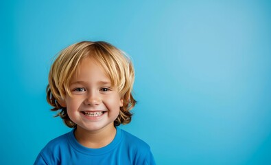 little boy smiling on blue background with space for text, advertising