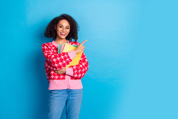 Portrait photo of girl with curly hair wearing eyeglasses hold books direct finger education courses ad isolated on blue color background