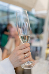 a man holds a glass of champagne in his hand at a celebration in a restaurant