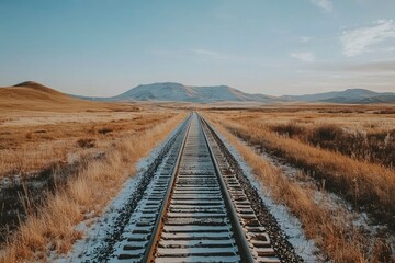 Fototapeta premium Train Tracks Leading Through a Snowy Mountain Valley