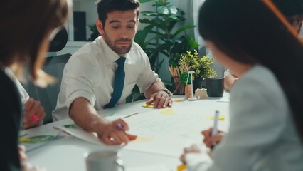 Professional smart business team discussing about using clean energy and sustainable investment at meeting table with wind mill, document with environmental graph and wooden house model. Alimentation.