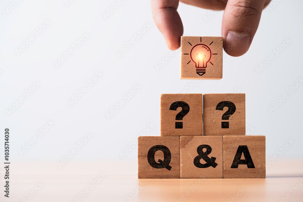 Poster hand putting glowing lightbulb on the top of wooden block cube on question mark and qa for problem s