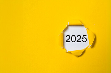 2025 inside yellow punch paper with copy space for preparation of merry Christmas and happy new year concept.